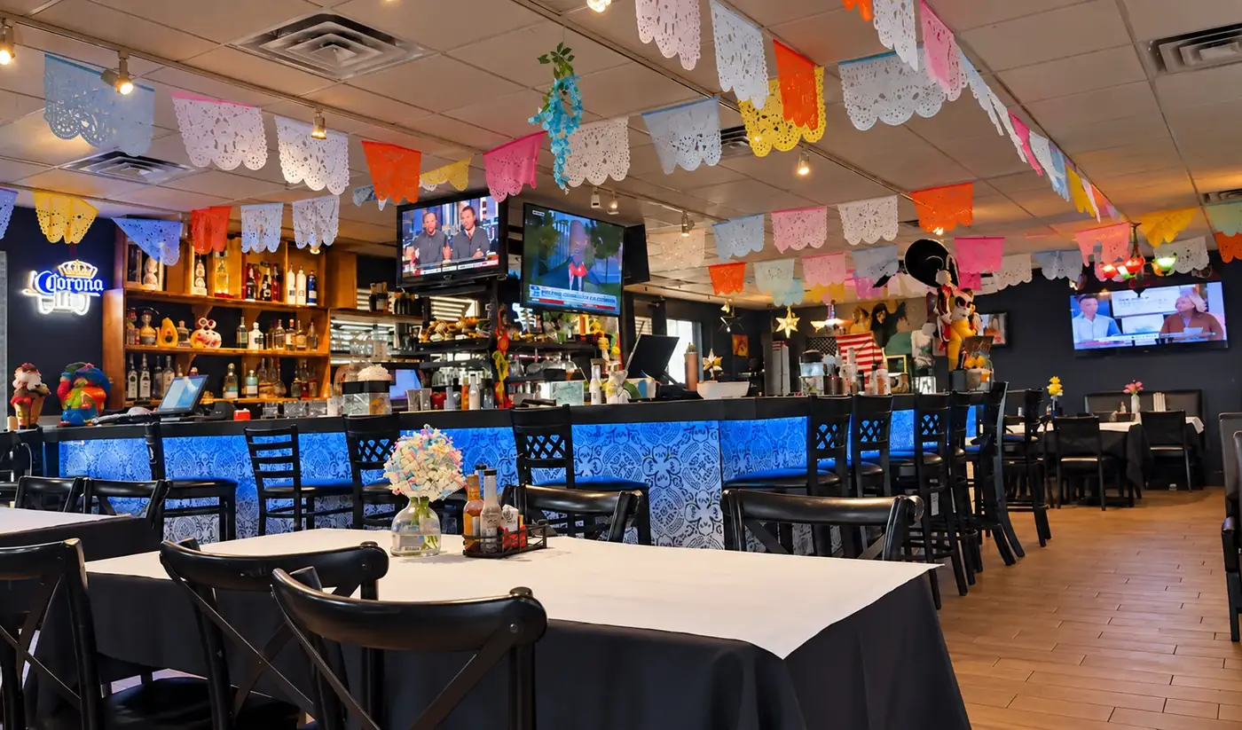 Colorful Chicanos dining room and illuminated bar decorated with papel picado